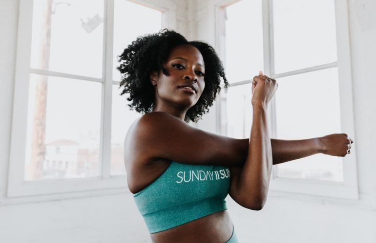 a woman in a sports bra top stretching her arms